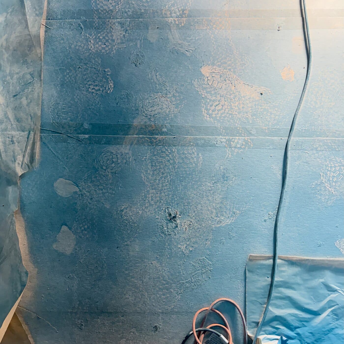 White footprints tracked across the blue floor paper